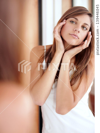 Mirror, facial massage and woman in bathroom for morning skincare routine, dermatology and beauty. Getting ready, reflection and girl with acupressure on face, cosmetics and skin care glow in home. 139446845