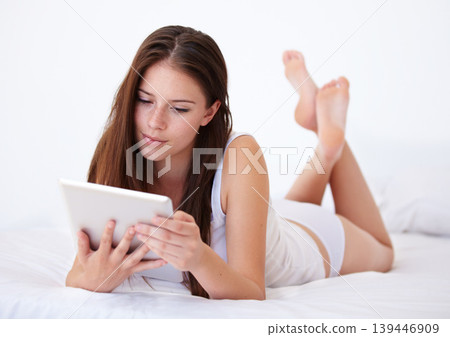 Relax, tablet and app with a woman in the bedroom of her apartment for browsing on the weekend. Technology, social media or streaming with a young person lying on a bed in her home for morning rest Relax, tablet and app with a woman in the bedroom of her apartment for browsing on the weekend. Technology, social media or streaming with a young person lying on a bed in her home for morning rest 139446909