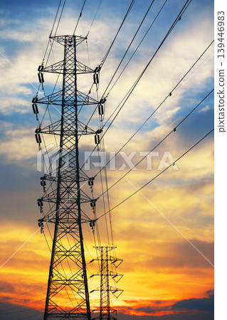 A landscape of transmission towers, power lines, and a sunset. 139446983