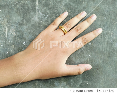 Close up of gold wedding ring. Ring gold wedding on finger hand Close up of gold wedding ring. Ring gold wedding on finger hand 139447120