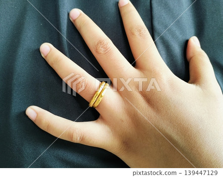 Close up of gold wedding ring. Ring gold wedding on finger hand Close up of gold wedding ring. Ring gold wedding on finger hand 139447129