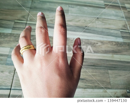 Close up of gold wedding ring. Ring gold wedding on finger hand Close up of gold wedding ring. Ring gold wedding on finger hand 139447130