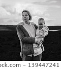 Mother enjoying winter vacations playing with his infant baby boy son on black sandy volcanic beach of Janubio on Lanzarote island, Spain on windy overcast day. Family travel vacations concept 139447241