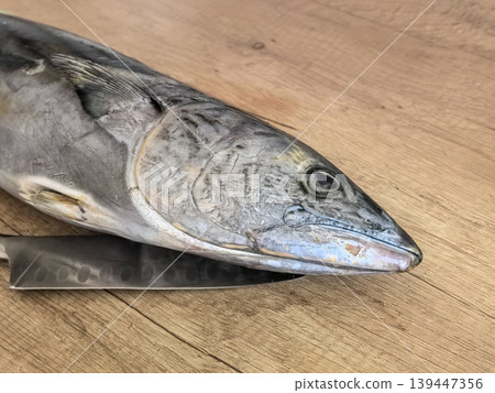 Raw Fish Head on Cutting Board with Kitchen Knife 139447356