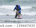 Wearing a fishing cooperative armband, they collect clams. 139447435