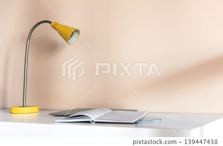 Minimal desk with open notebook and yellow lamp Minimal desk with open notebook and yellow lamp 139447438