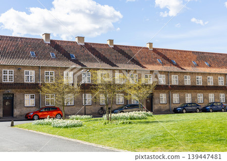 Old residential building with tiled roof and chimney under blue sky Old residential building with tiled roof and chimney under blue sky 139447481