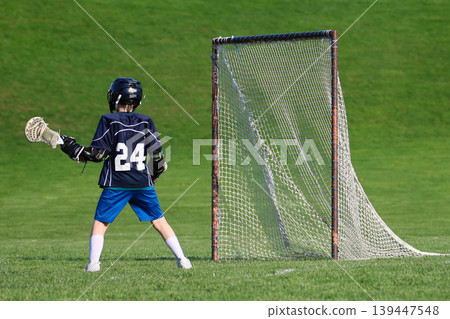 Boy playing Lacrosse game 139447548