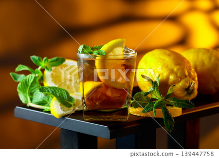 Iced black tea with lemon wedges, ice cubes and mint leaves. Iced black tea with lemon wedges, ice cubes and mint leaves. 139447758