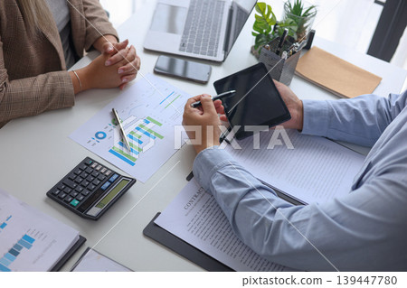 Professional Team Collaborating on Financial Data and Business Strategy in Modern Office. Professional Team Collaborating on Financial Data and Business Strategy in Modern Office. 139447780