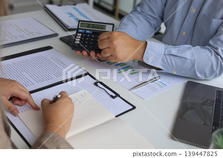 Two Business Partners Discussing Analyzing Financial Data and Business Strategy for Budget Planning in Modern Office. Two Business Partners Discussing Analyzing Financial Data and Business Strategy for Budget Planning in Modern Office. 139447825