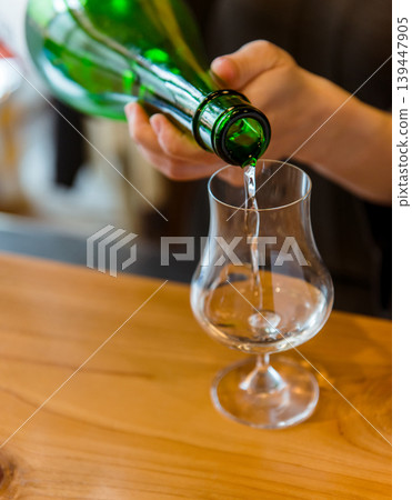 將清酒倒入酒杯的場景。 將清酒倒入酒杯的場景。 139447905