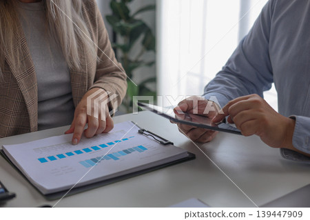 Coworkers Collaborating Brainstorming on Analyzing Data Charts with Laptop or Tablet on the Office Desk. Coworkers Collaborating Brainstorming on Analyzing Data Charts with Laptop or Tablet on the Office Desk. 139447909