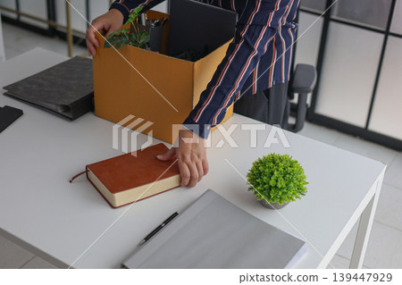 Businesswoman Packing Belongings in Box After Resignation or Layoff. Businesswoman Packing Belongings in Box After Resignation or Layoff. 139447929