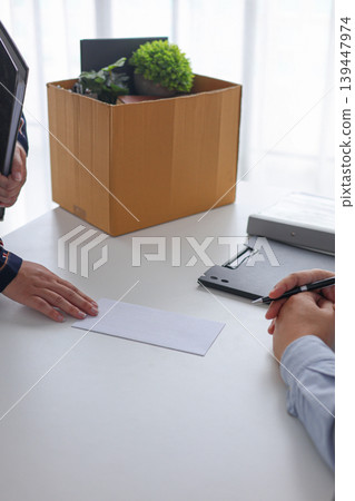 Female Professional Resigning from Position Handing Resignation Letter to Manager in Office. Female Professional Resigning from Position Handing Resignation Letter to Manager in Office. 139447974