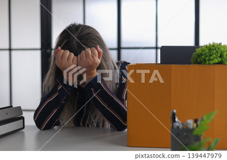 Sad Businesswoman Packing Personal Items After Being Fired. 139447979
