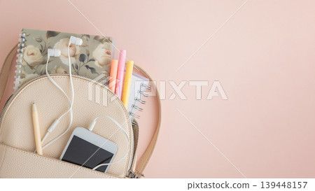 Backpack with notebook, phone, and earphones on pink background Backpack with notebook, phone, and earphones on pink background 139448157