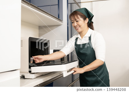 一位做家事和做飯的女性。 一位做家事和做飯的女性。 139448208