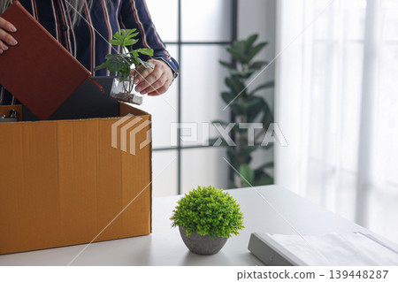 Close-up of Employee Packing Stuff from Working Desk After Quitting Job. Close-up of Employee Packing Stuff from Working Desk After Quitting Job. 139448287