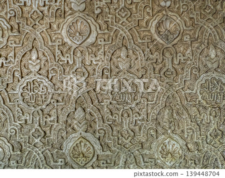 Carved Islamic Plaster Wall With Ornate Arabic Geometric Patterns And Intricate Arabesque Ornamentation, Alhambra, Granada Carved Islamic Plaster Wall With Ornate Arabic Geometric Patterns And Intricate Arabesque Ornamentation, Alhambra, Granada 139448704
