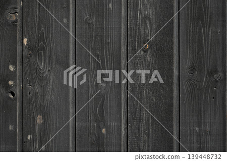 Weathered vertical wood texture featuring dark, aged wooden tones, suitable for architectural or design projects. 139448732