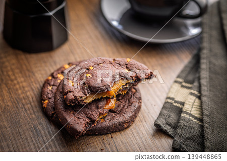 Warm Chocolate Cookies Filled With Gooey Caramel Served With Coffee On Wooden Table Warm Chocolate Cookies Filled With Gooey Caramel Served With Coffee On Wooden Table 139448865