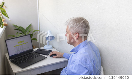 Man studying numbers on the laptop screen on the modern desk showing spreadsheet with loan amortization table Man studying numbers on the laptop screen on the modern desk showing spreadsheet with loan amortization table 139449020