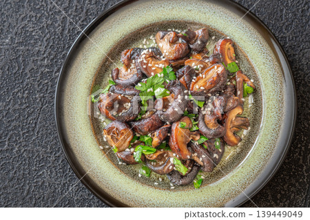 Pan fried shiitake mushrooms with sesame seeds on artisanal ceramic plate Pan fried shiitake mushrooms with sesame seeds on artisanal ceramic plate 139449049