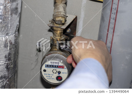 Plumber repairing a residential water meter Plumber repairing a residential water meter 139449064