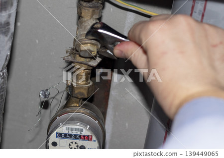 Plumber repairing a residential water meter 139449065