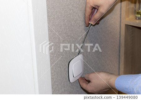 Electrician installing lighting switch. Interiors 139449080