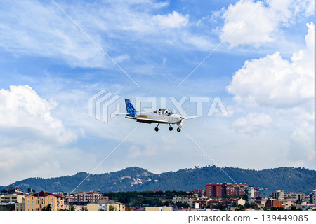 Single engine ultralight plane flying in the blue sky with white clouds 139449085