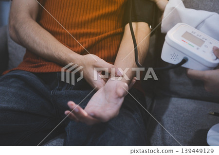 Doctor checks patient's blood pressure with cuff and stethoscope in a medical 139449129