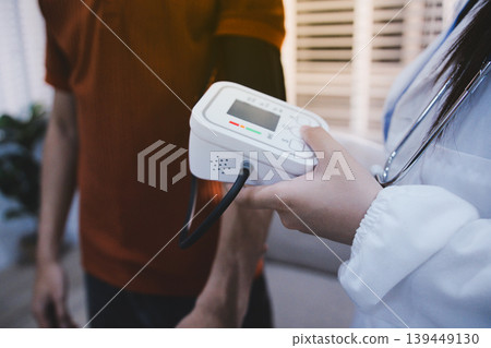 Doctor checks patient's blood pressure with cuff and stethoscope in a medical 139449130