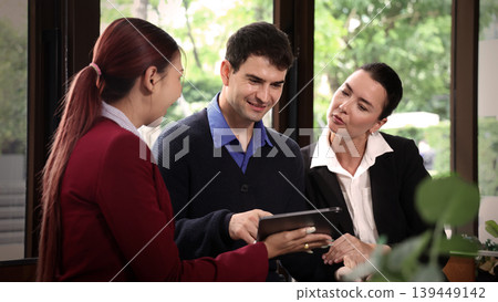 Deal Business. Business professionals discussing projects and digital information on tablet during corporate meeting. Team collaboration communication connect and client consultation in modern office Deal Business. Business professionals discussing projects and digital information on tablet during corporate meeting. Team collaboration communication connect and client consultation in modern office 139449142
