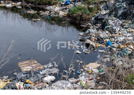 Plastic waste crowds the surface of the water in a local lake while trash surrounds the shoreline and some land nearby Plastic waste crowds the surface of the water in a local lake while trash surrounds the shoreline and some land nearby 139449250