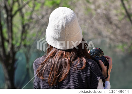 A woman photographing a forest of fresh green leaves. A woman photographing a forest of fresh green leaves. 139449644
