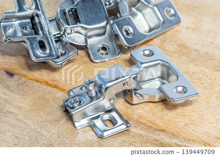 Close-up of cabinet mounting hardware on a wooden background. Close-up of cabinet mounting hardware on a wooden background. 139449709
