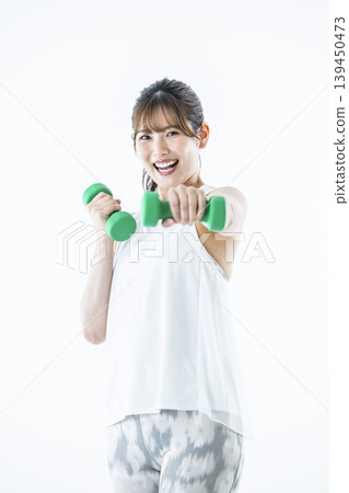 Young women sportswear looking at the camera dumbbell punch 139450473