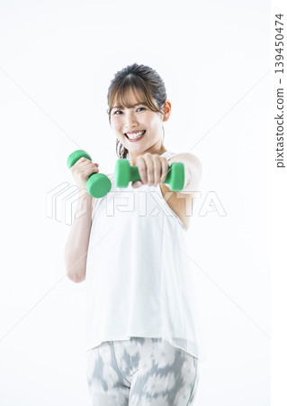 年輕女子運動服看著相機啞鈴拳 年輕女子運動服看著相機啞鈴拳 139450474