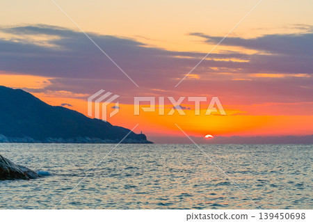 A sacred sunset over Yakushima Island: The setting sun and the Yakushima Lighthouse (winter) A sacred sunset over Yakushima Island: The setting sun and the Yakushima Lighthouse (winter) 139450698