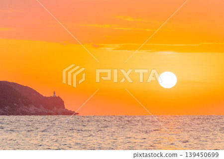 A sacred sunset over Yakushima Island: The setting sun and the Yakushima Lighthouse (winter) A sacred sunset over Yakushima Island: The setting sun and the Yakushima Lighthouse (winter) 139450699