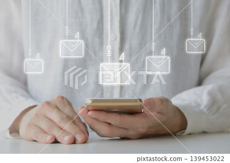 Image of a person receiving multiple phishing emails on their smartphone. Image of a person receiving multiple phishing emails on their smartphone. 139453022