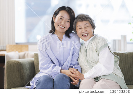 一位老年婦女和一位中年婦女面帶微笑地看著鏡頭,構成了一幅母女肖像。 一位老年婦女和一位中年婦女面帶微笑地看著鏡頭,構成了一幅母女肖像。 139453298