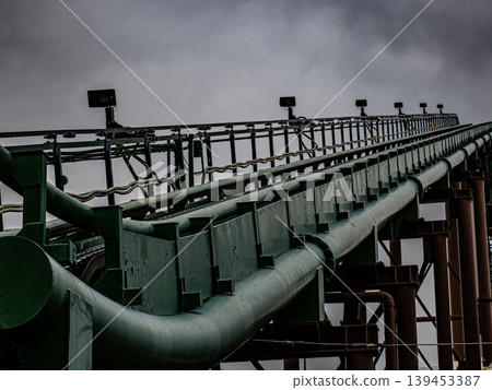 The image of a roller coaster track stretching beneath dark clouds evokes a sense of unease. 139453387