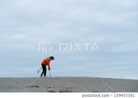 人們在海灘上撿垃圾 人們在海灘上撿垃圾 139453391