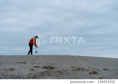 人們在海灘上撿垃圾 139453392