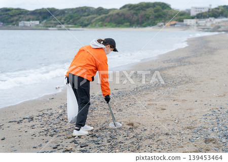人們在海灘上撿垃圾 人們在海灘上撿垃圾 139453464