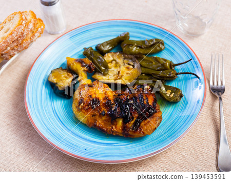 Baked or fried chicken thigh with vegetables, whole peppers and eggplant Baked or fried chicken thigh with vegetables, whole peppers and eggplant 139453591