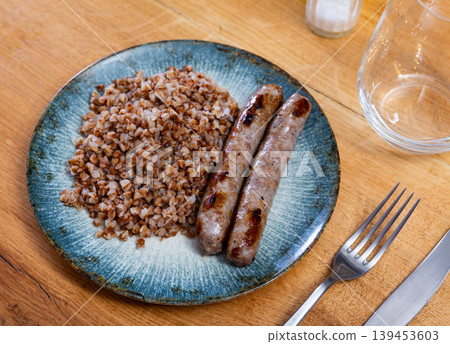 Fried sausages served with buckwheat groats Fried sausages served with buckwheat groats 139453603